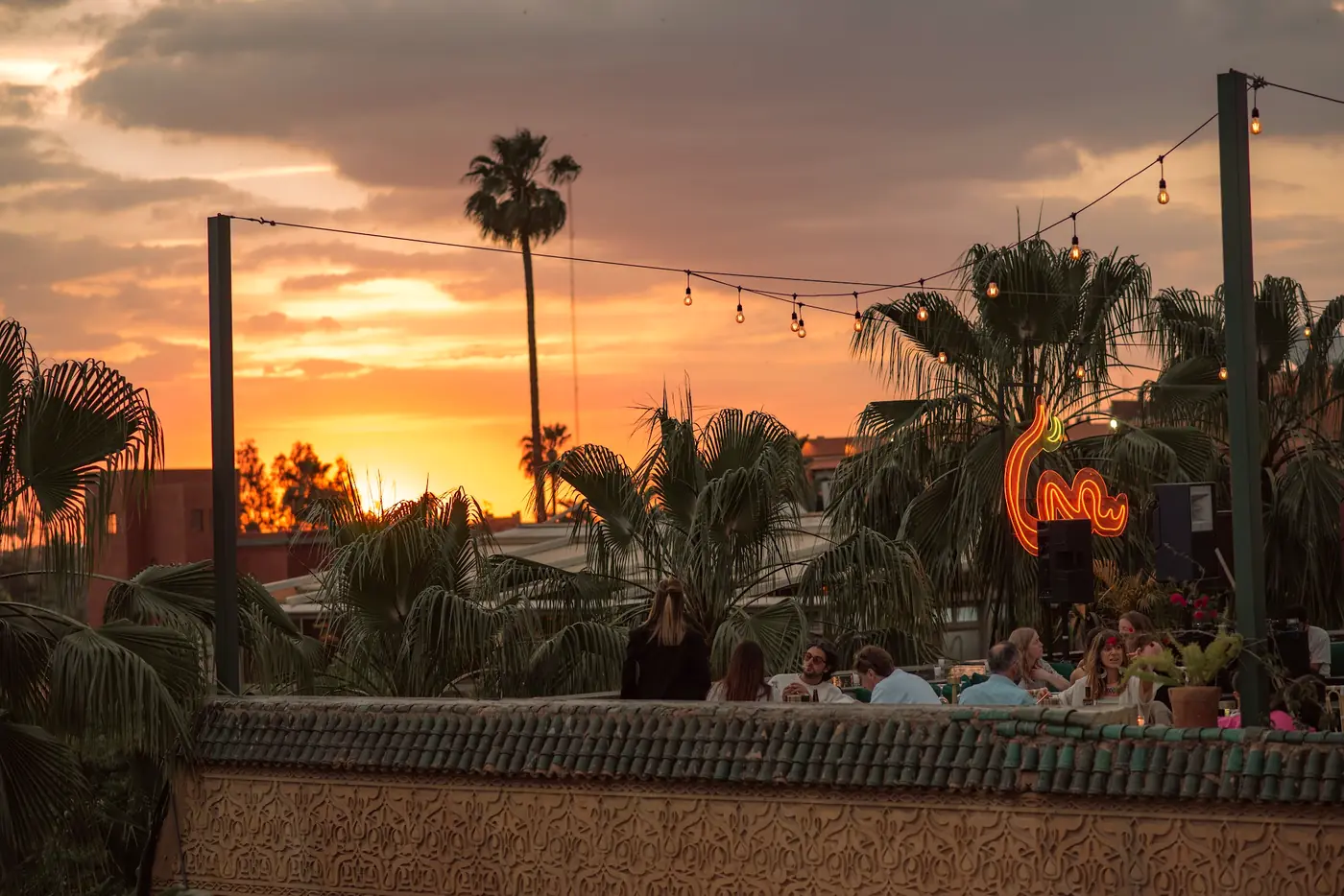Le rooftop SAMA au coucher du soleil, terrasse dressée face aux palmiers